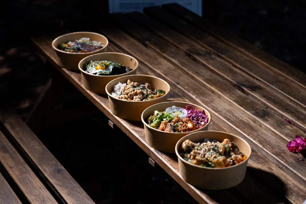 A row of Streatery bowls prepared for an office lunch order