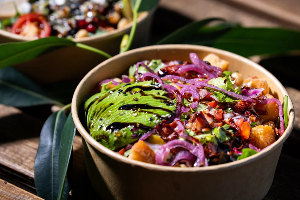 A plant-based Streatery bowl with avocado, pomegranate and pickled onion