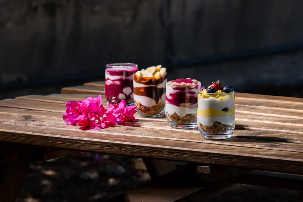 Four Heirloom cheesecake cups with fruit and caramel layers